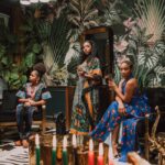 A vibrant Kwanzaa celebration featuring women in traditional African attire in a beautifully decorated setting.